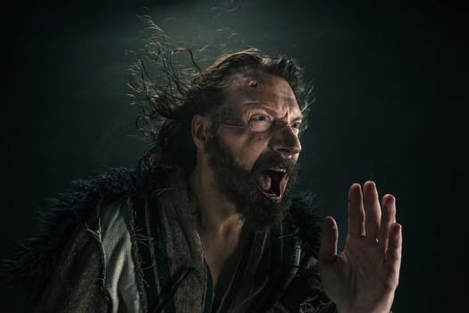 Portrait of a brutal bald-headed viking in a battle mail posing against a black background. Early medieval period.
