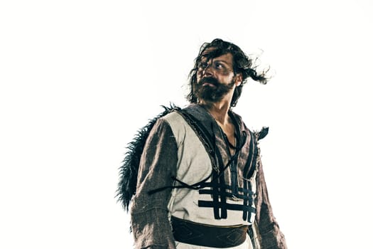 Portrait of a brutal bald-headed viking in a battle isolated against a white background. Early medieval period. Actor in makeup. concept of vagrancy and survival
