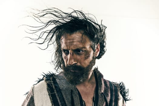 Portrait of a brutal bald-headed viking in a battle isolated against a white background. Early medieval period. Actor in makeup. concept of vagrancy and survival