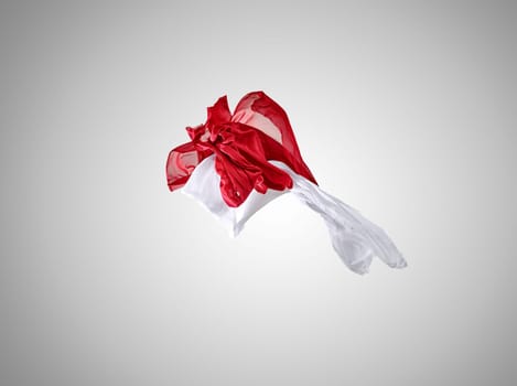 Smooth elegant transparent red and white cloth separated on gray background. Texture of flying fabric.