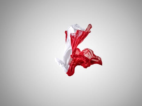 Smooth elegant transparent red and white cloth separated on gray background. Texture of flying fabric.