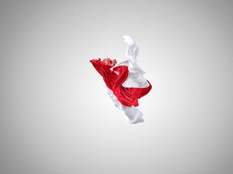 Smooth elegant transparent red and white cloth separated on gray background. Texture of flying fabric.