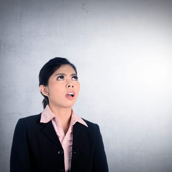Asian business woman get shocked over grunge wall background