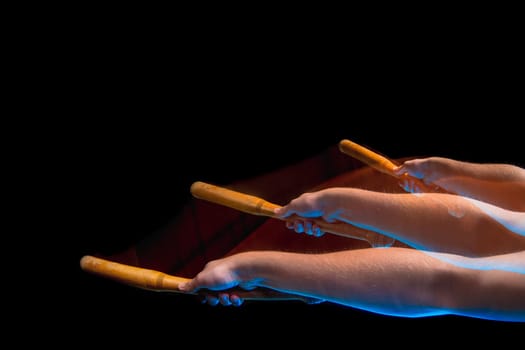 The arm with wooden baseball bat on black studio background. Stroboscope shooting technique