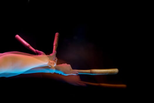 The arm with wooden baseball bat on black studio background. Stroboscope shooting technique