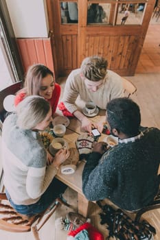 A group of teenagers sitting in a circle enjoying coffee and chatting in winter.