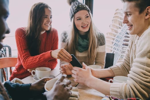 Teenagers socialising in a cafe in winter.
