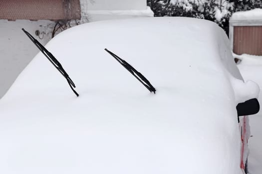 Winter in road traffic. A snow-covered red car