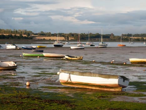 estuary scene in manningtree with moored boats tide clouds landscape