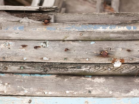 close up texture of decaying wooden boat with rusty nails