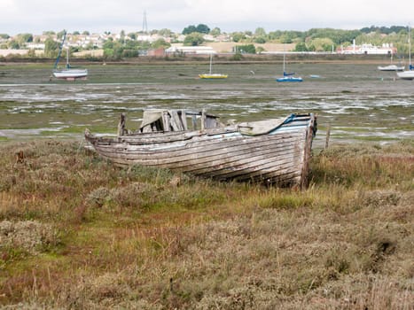 old wooden boat ruins decaying abandoned estuary scene