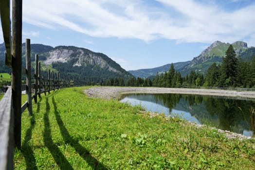 Alpine landscape in summer,in the foreground a storage pond
