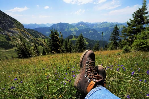Young man takes a break in the Alps,you can see the mountain boots
