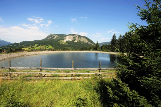 Alpine landscape in summer,in the foreground a storage pond
