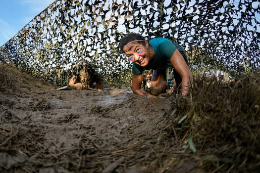 ESTARREJA, PORTUGAL - SEPTEMBER 23: Athletes crawling through mud at the Biorace on september 23, 2017 in Estarreja, Portugal.