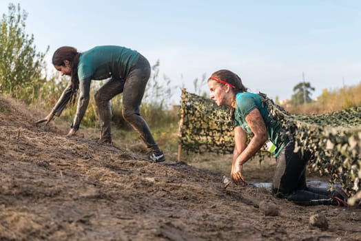 ESTARREJA, PORTUGAL - SEPTEMBER 23: Athletes crawling through mud at the Biorace on september 23, 2017 in Estarreja, Portugal.