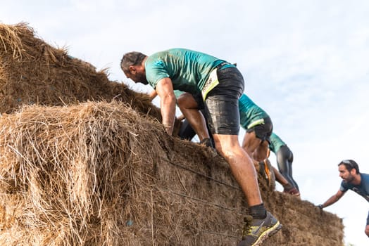 ESTARREJA, PORTUGAL - SEPTEMBER 23: Athletes overcoming the hay osbtacle at the Biorace on september 23, 2017 in Estarreja, Portugal.