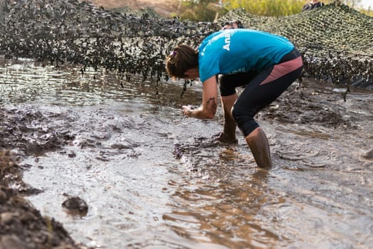 ESTARREJA, PORTUGAL - SEPTEMBER 23: Athletes crawling through mud at the Biorace on september 23, 2017 in Estarreja, Portugal.