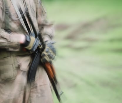 close up on soldier with machine gun,motion blur