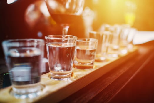 close up on vodka shots and other alcohols in a row