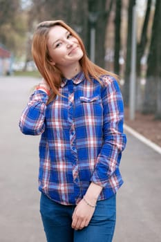 Portrait of a beautiful girl. smiling, posing on camera. in a blue shirt in a cage. On the background Wooden grid grid.
