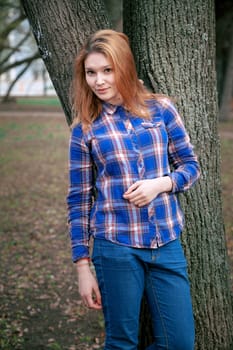 Portrait of a beautiful girl. smiling, posing on camera. in a blue shirt in a cage. On the background Wooden grid grid.