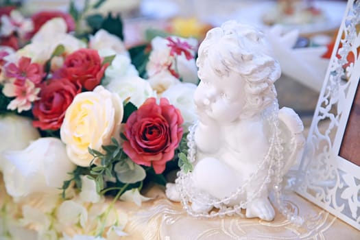 a statue of an angel in an interior with flowers. decorating holidays