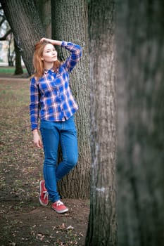 Portrait of a beautiful girl. smiling, posing on camera. in a blue shirt in a cage. On the background Wooden grid grid.