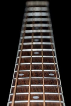 Acoustic  Bass Guitar Fretboard Close Up with black background.