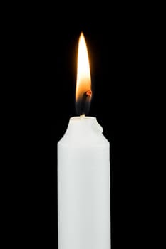 White burning candle,festive symbol against a black background