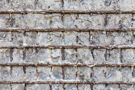 Fragment of a gray concrete wall with metal structures,background