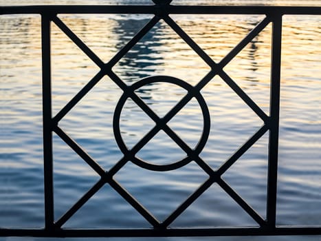 The shapes of a fence with water behind
