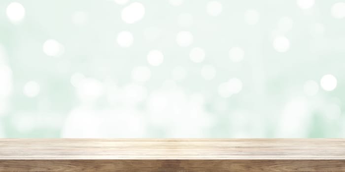 Empty wooden table top with blurred light green natural abstract background. Panoramic banner. Can be used product display.