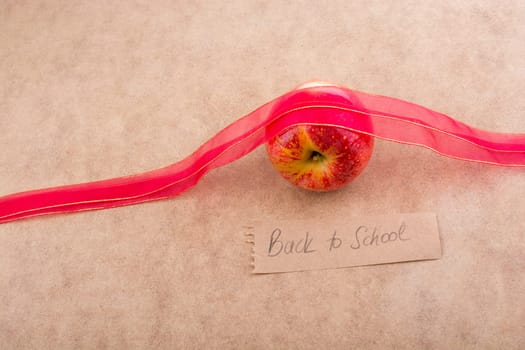 Back to school lettering with apple and a red ribbon
