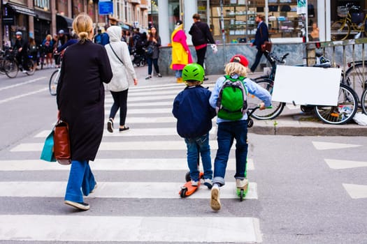 Funny children skate on the scooters at the crossroads. ferrying