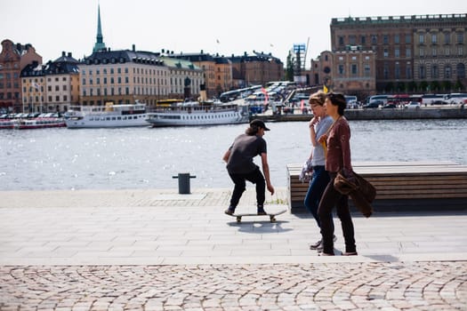 Stockholm, Sweden - June 10, 2017 : Urban life. Cool skateboarder outdoors Scandinavian guy performing a trick with his skate on the street