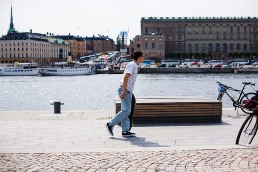 Stockholm, Sweden - June 10, 2017 : Urban life. Cool skateboarder outdoors Scandinavian guy performing a trick with his skate on the street