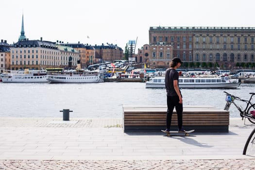 Stockholm, Sweden - June 10, 2017 : Urban life. Cool skateboarder outdoors Scandinavian guy performing a trick with his skate on the street