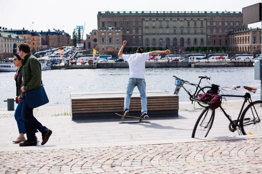 Stockholm, Sweden - June 10, 2017 : Urban life. Cool skateboarder outdoors Scandinavian guy performing a trick with his skate on the street