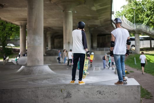 Powerful funny young guys are trained in a skate park Stockholm, Sweden. Leisure, playing, trick