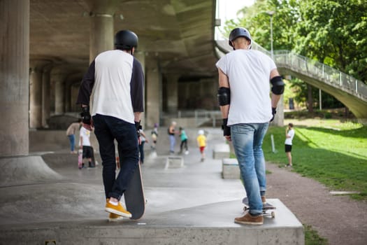 Powerful funny young guys are trained in a skate park Stockholm, Sweden. Leisure, playing, trick