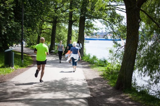 Powerful happy elderly people are walking, running early in the park Stockholm, Sweden