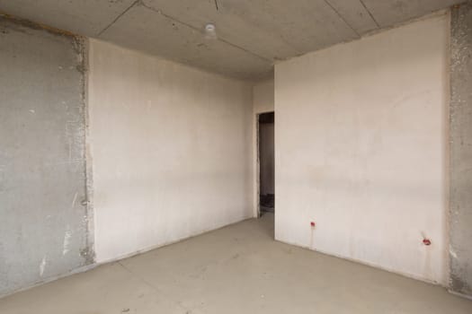 Entrance to the room in the new building, plastered and concrete walls