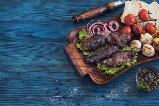 Grilled lamb meat with vegetable on a blue wooden background