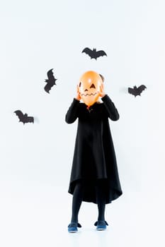 Little girl witch in black long dress and magical accessories. Halloween, the studio evening.