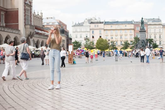 Krakow, Poland - July 29, 2017 : Tourist taking photos with his smartphone in historiccal center of city