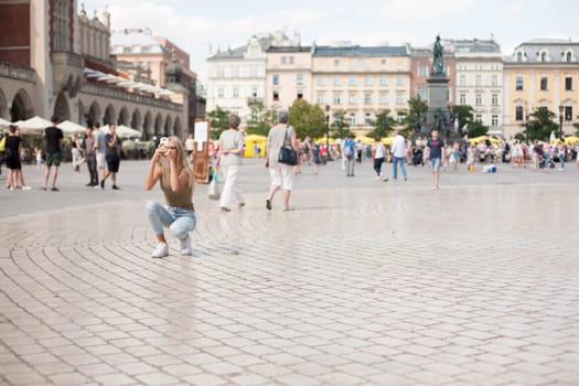 Krakow, Poland - July 29, 2017 : Tourist taking photos with his smartphone in historiccal center of city