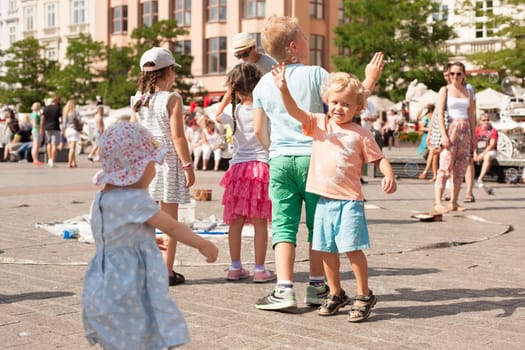 Krakow, Poland - July 29, 2017 : Children play with soap bubbles in the central square of old city. Urban life