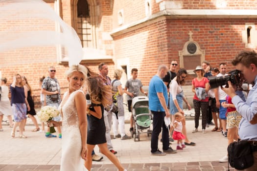 Krakow, Poland - July 29, 2017 : The photographer takes pictures of the bride in historical city, beautiful fairytale wedding
