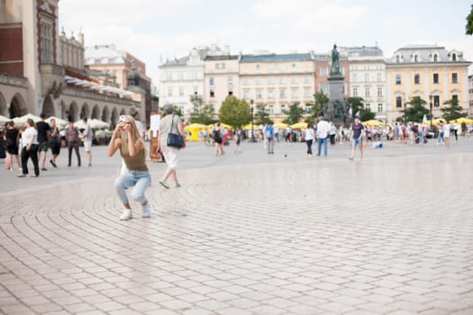 Krakow, Poland - July 29, 2017 : Tourist taking photos with his smartphone in historiccal center of city
